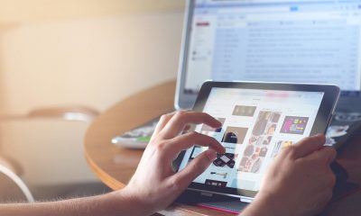 媒体从业者在宽敞办公室内用多屏电脑核实黑料新闻线索，专业严肃的工作环境，冷色调专业感